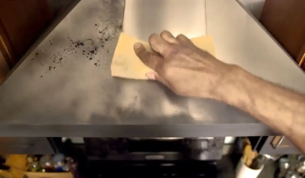 Cleaning soot residue from a commercial kitchen hood surface