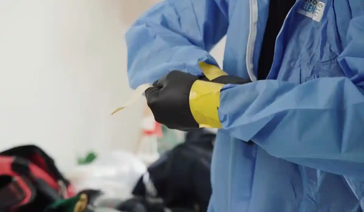 Technician in full protective gear performing mold removal work