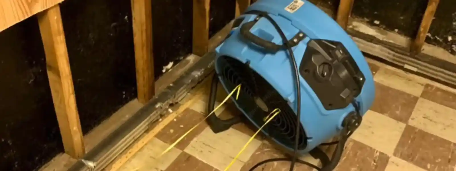 Restoration equipment including air movers and a dehumidifier set up in a room during drying